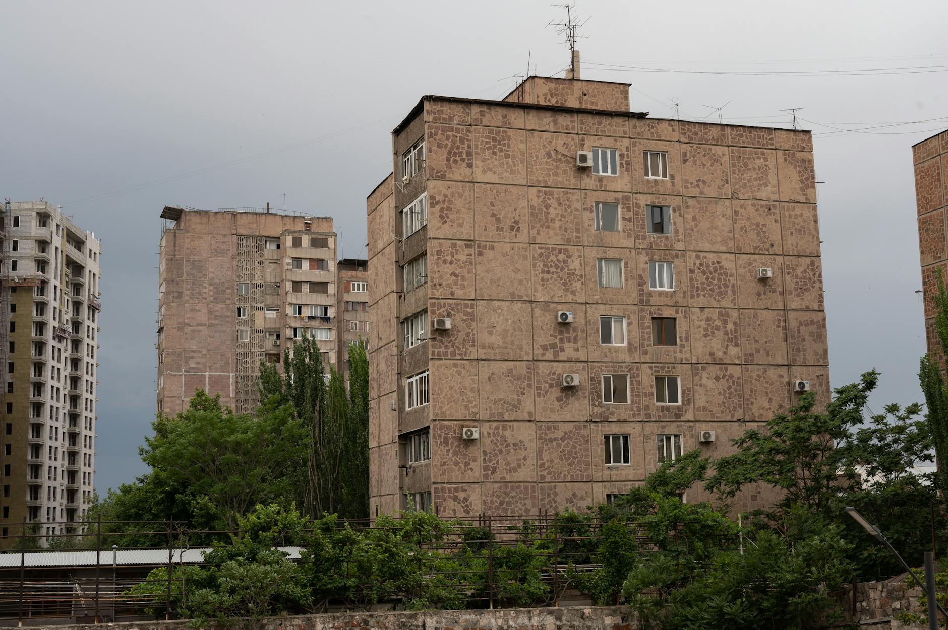 Blok miejskich kamienic na tle pochmurnego, szarego nieba