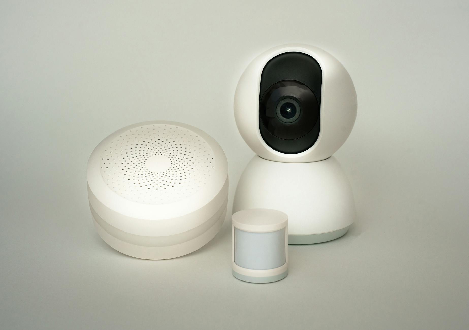 Kamera i czujniki inteligentnego systemu alarmowego na jasnym tle