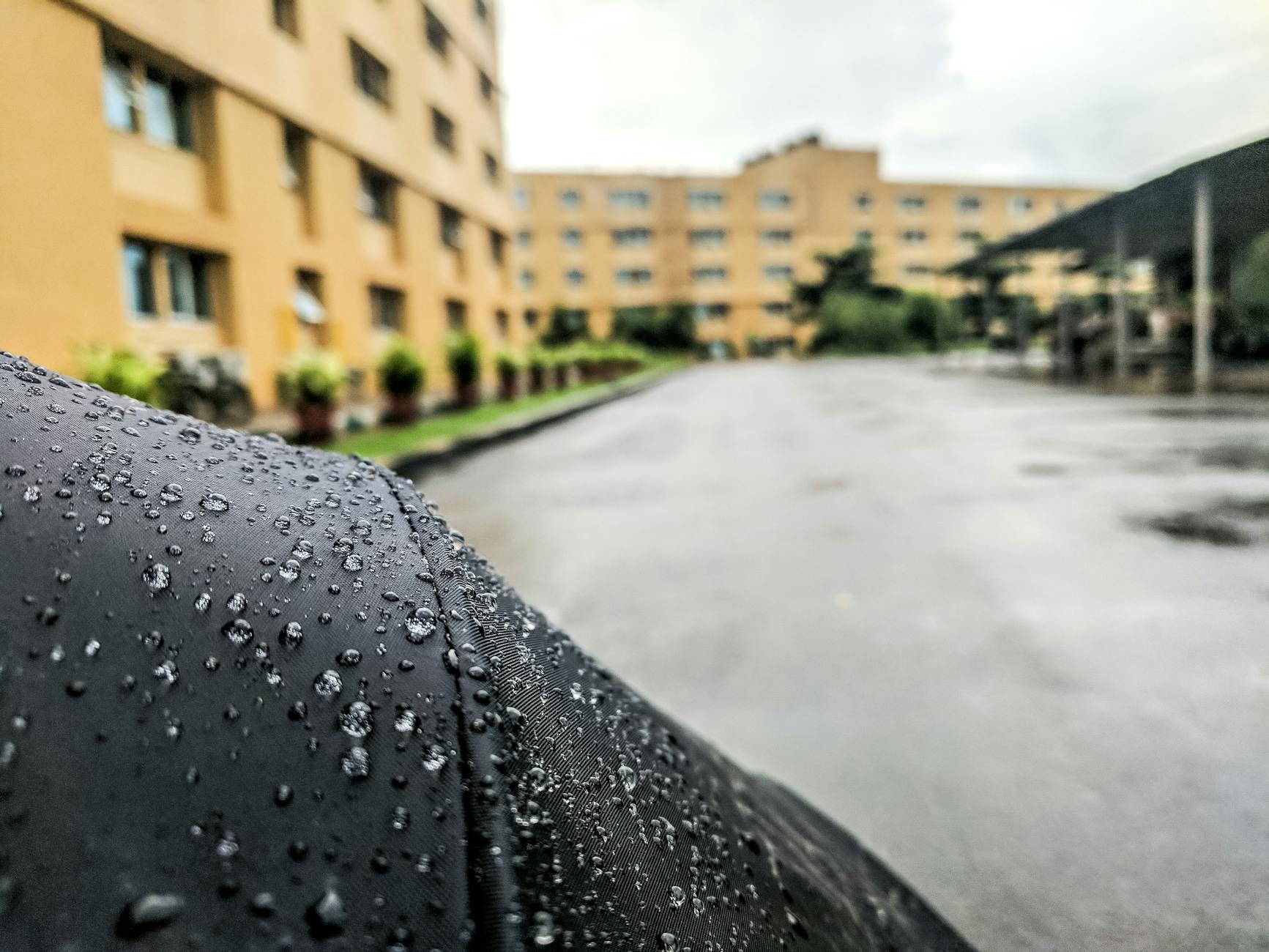 Krople deszczu na powierzchni z rozmytymi budynkami w tle