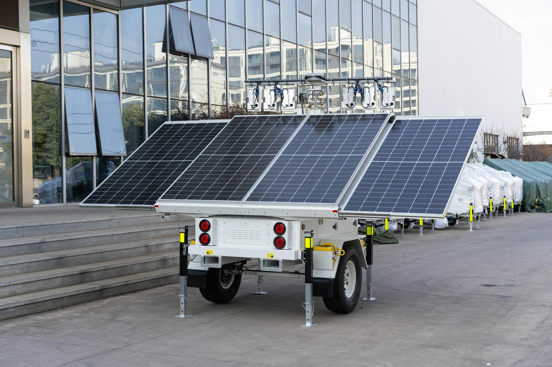 Przyczepa z panelem solarnym ustawiona przy nowoczesnym budynku