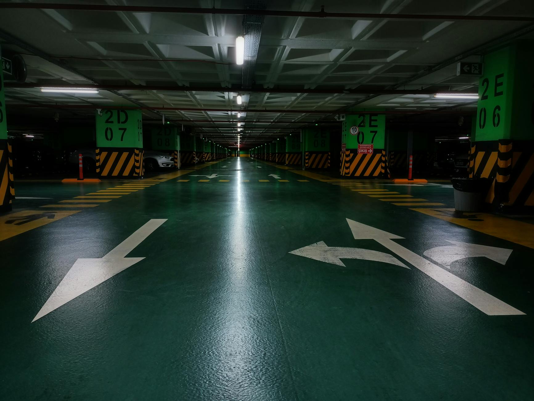 Podziemny parking z zielonym oznakowaniem i ledowym oświetleniem